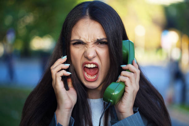 Young woman using a smart phone and a vintage analog phone